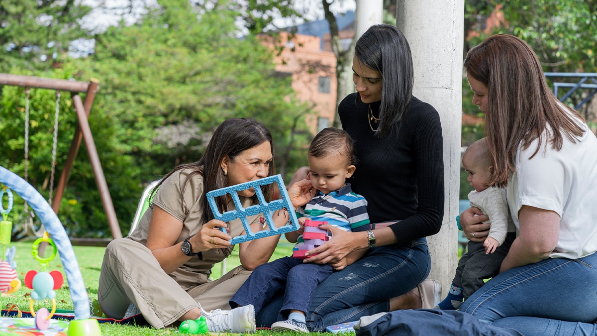 woman sitting in a field with their children