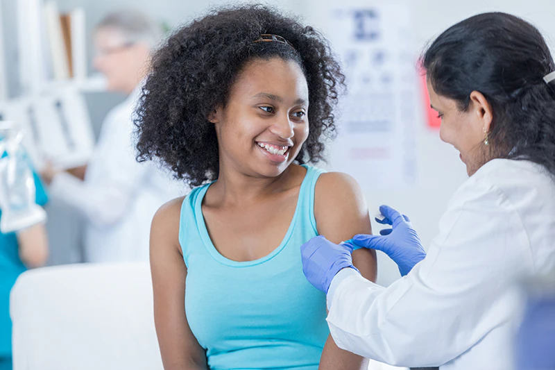 Healthcare provider applying a bandage to a pediatric patient's arm.