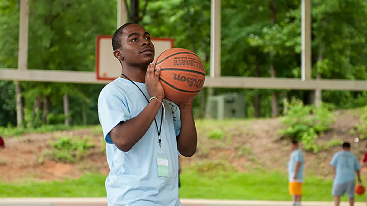 Boy shooting basketball at a park