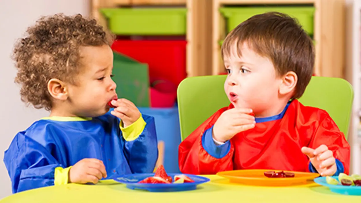 Young children eating strawberries.