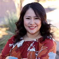 Latina woman with dark hair and red shirt smiling