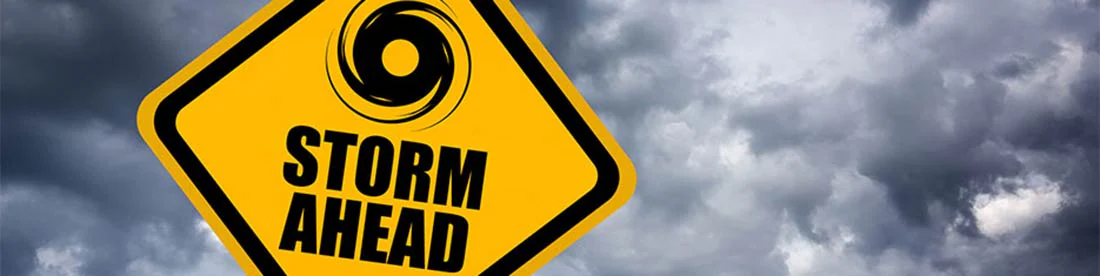 Una señal de tráfico amarilla con nubes oscuras detrás de él y un ícono de un huracán y las palabras "Tormenta por delante" significan precaución Una señal de tráfico amarilla con nubes oscuras detrás de él y un ícono de un huracán y las palabras "Tormenta por delante" significan precaución