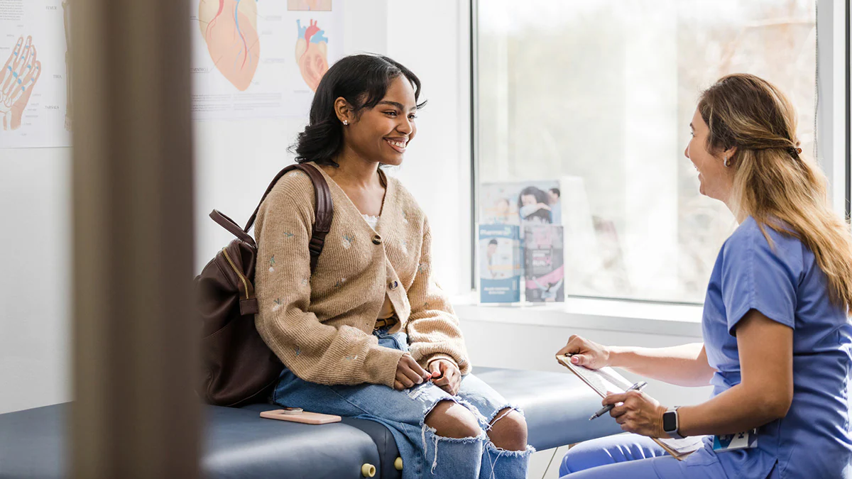 A young woman sitting and talking with her doctor