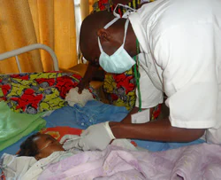 A flu surveillance nurse collects a sample from a child with acute respiratory illness at a local hospital in Rwanda.