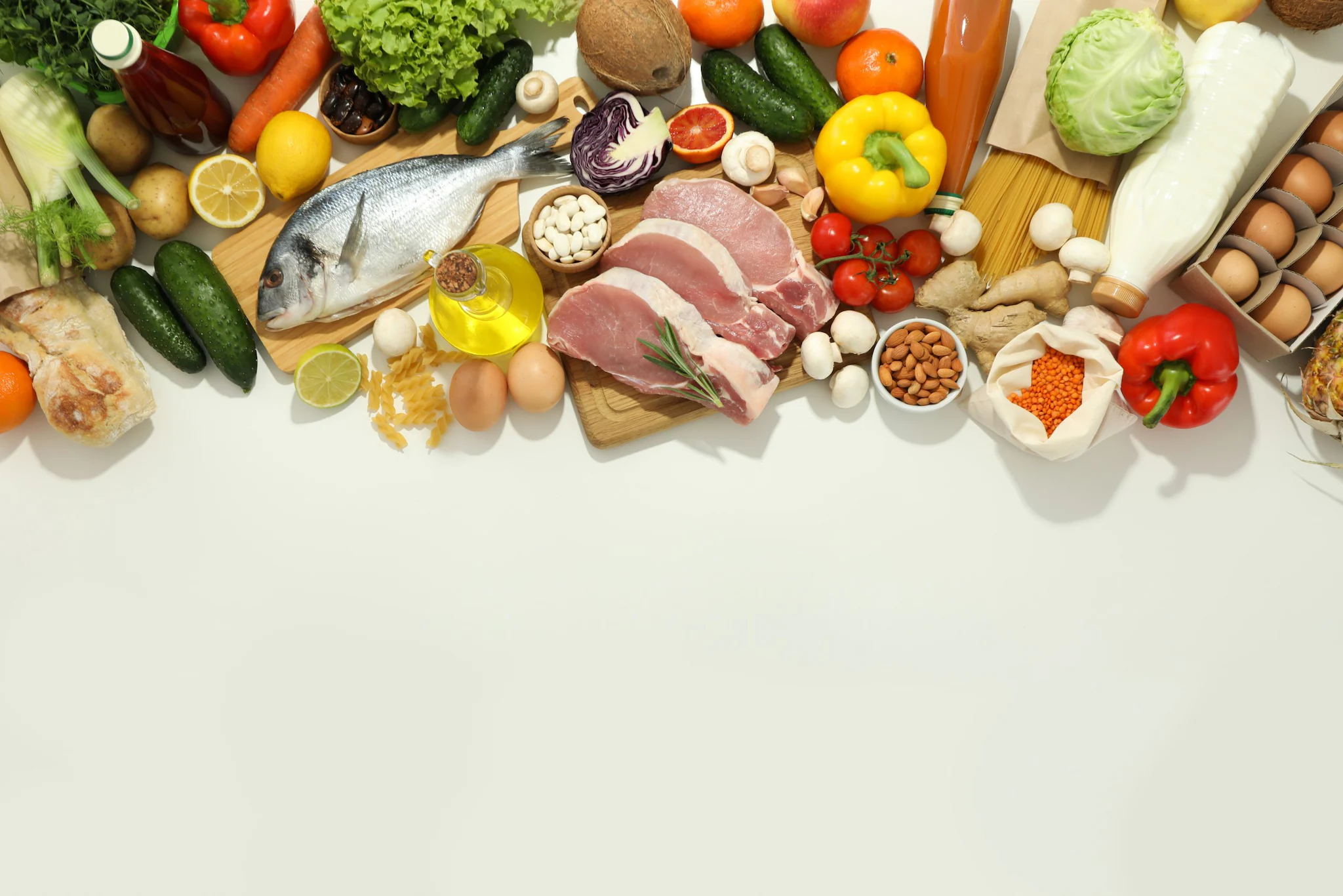 Images shows a spread of several types of foods like fruits, vegetables, fish, eggs, meats, nuts, milk, and bread.