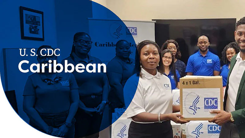 Group of people at a U.S. CDC Caribbean event, holding boxes with CDC logo.