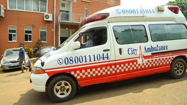 An ambulance is seen driving down a street in Kampala.