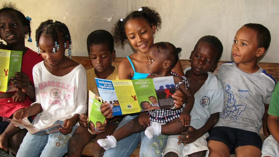 Group of children sit on a bench and look at pamphlets