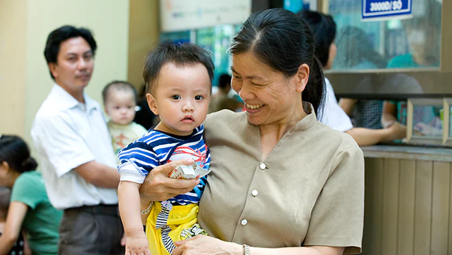 Mother holding child and smiling.