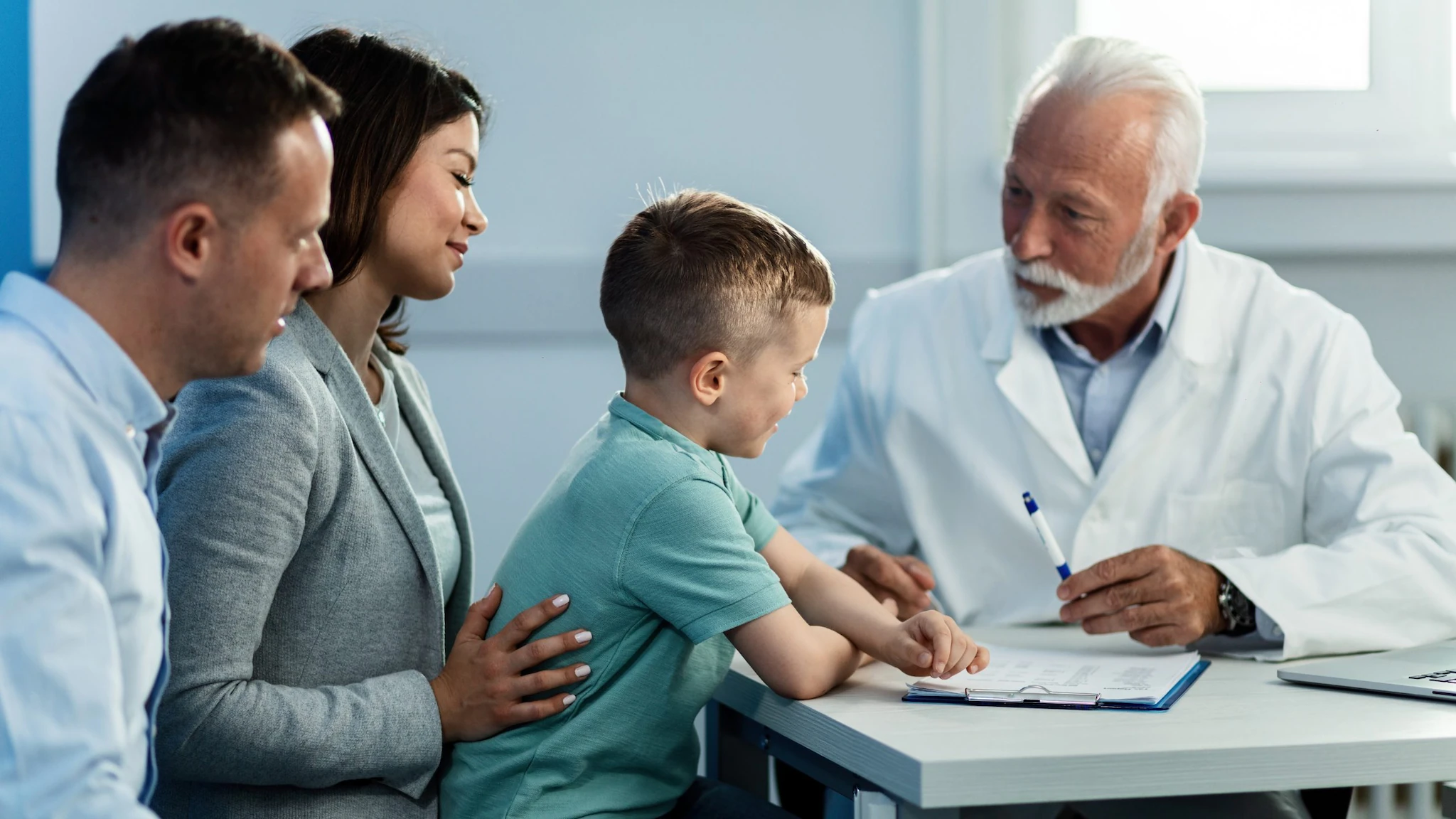 A healthcare provider talking to a couple and their chlid.