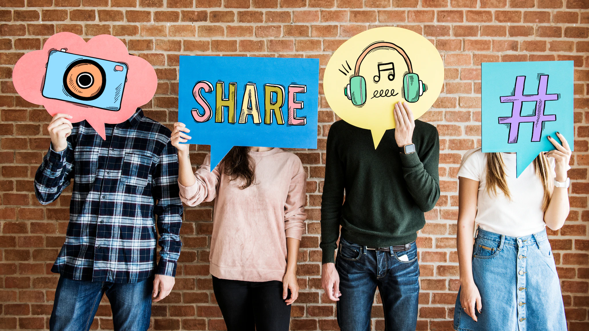 Students holding cardboard icons in front of their faces showing communication resources: share, hashtag, etc.