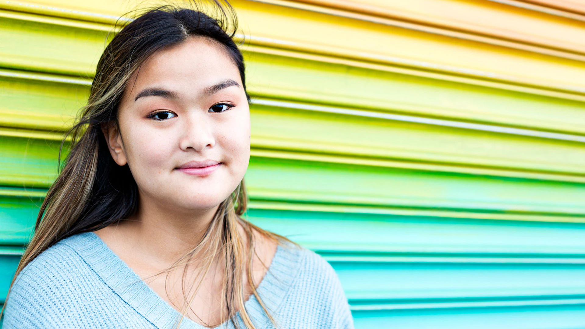 An LGBTQ teen smiling.