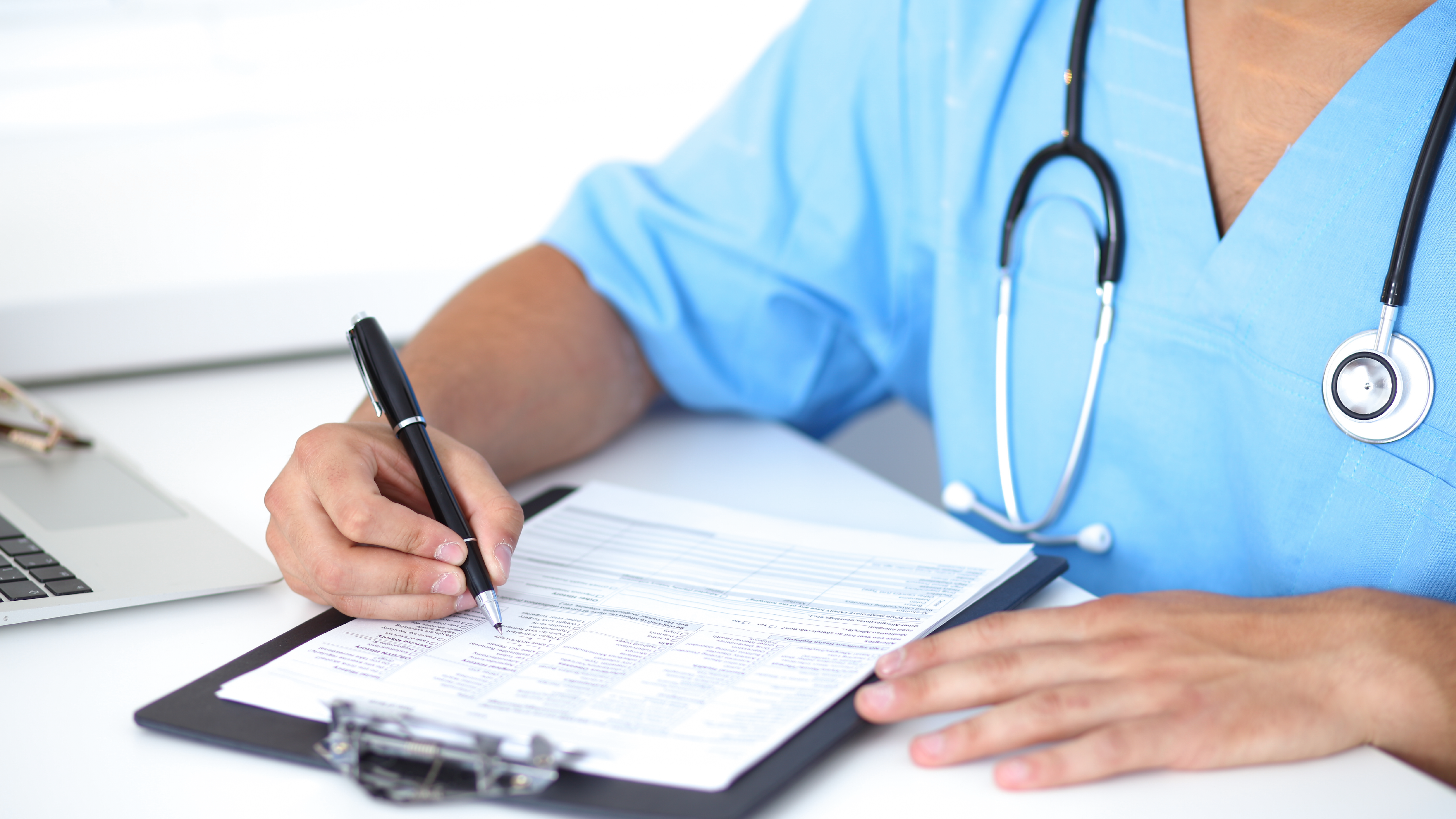 A health care provider writing on a piece of paper.