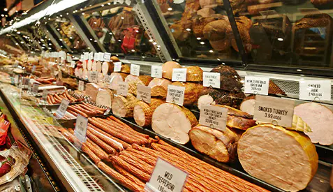 Display case in a store containing deli meats and cheeses.