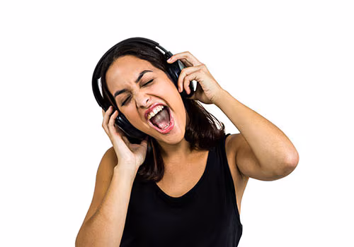 intro01 Woman wearing headphones and singing. Her hands are on each earpiece.