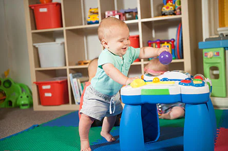 Baby standing and playing with toy