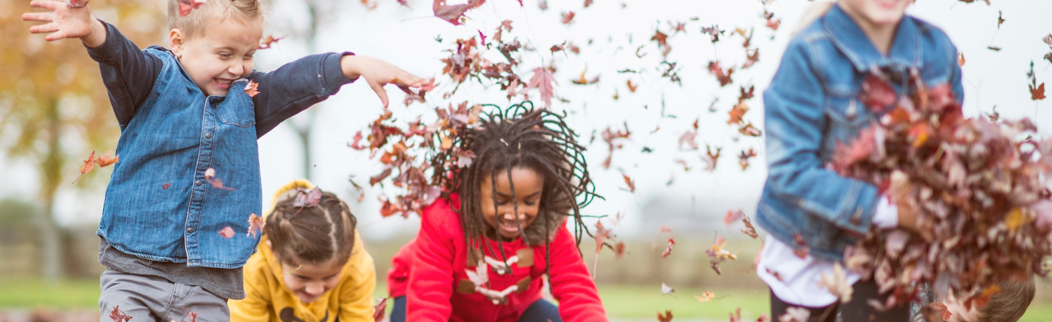 Kids throwing leaves in the air playing