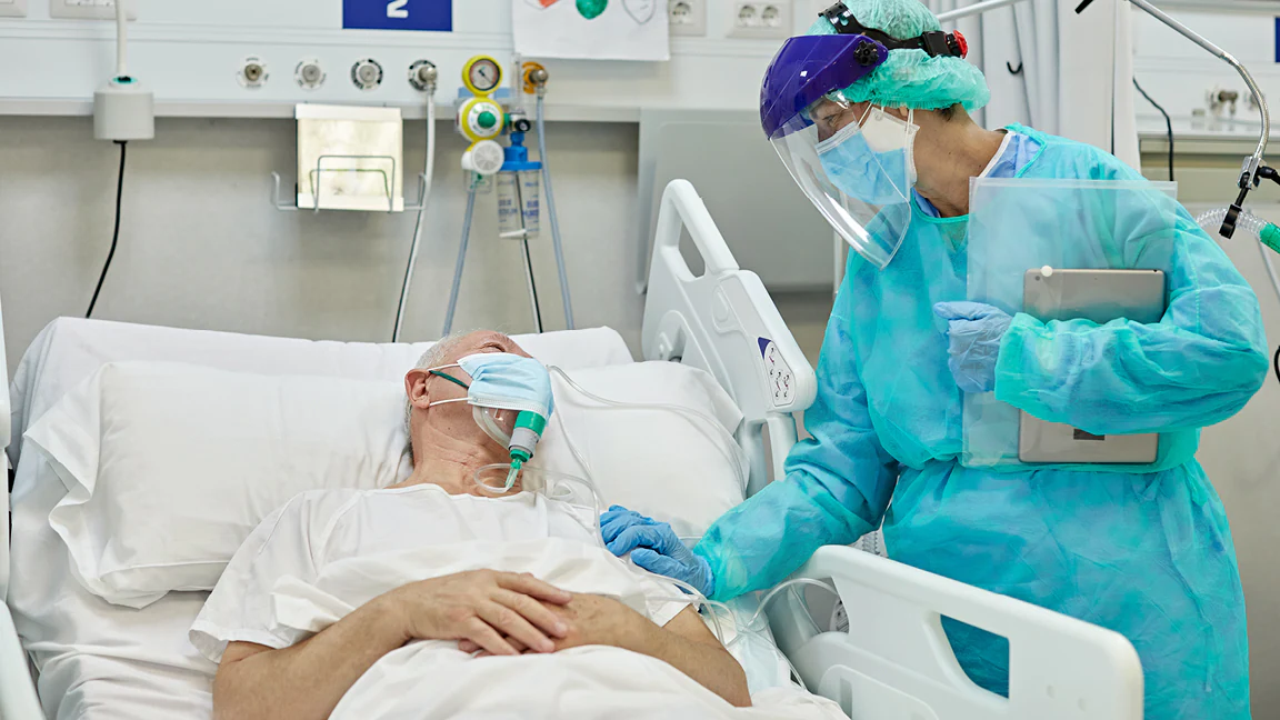 Photo of a healthcare provider checking on a hospital patient