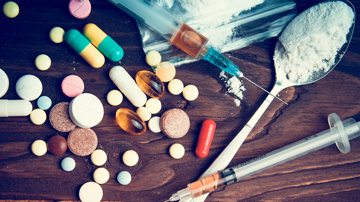 Assortment of illicit drugs on a dark table.