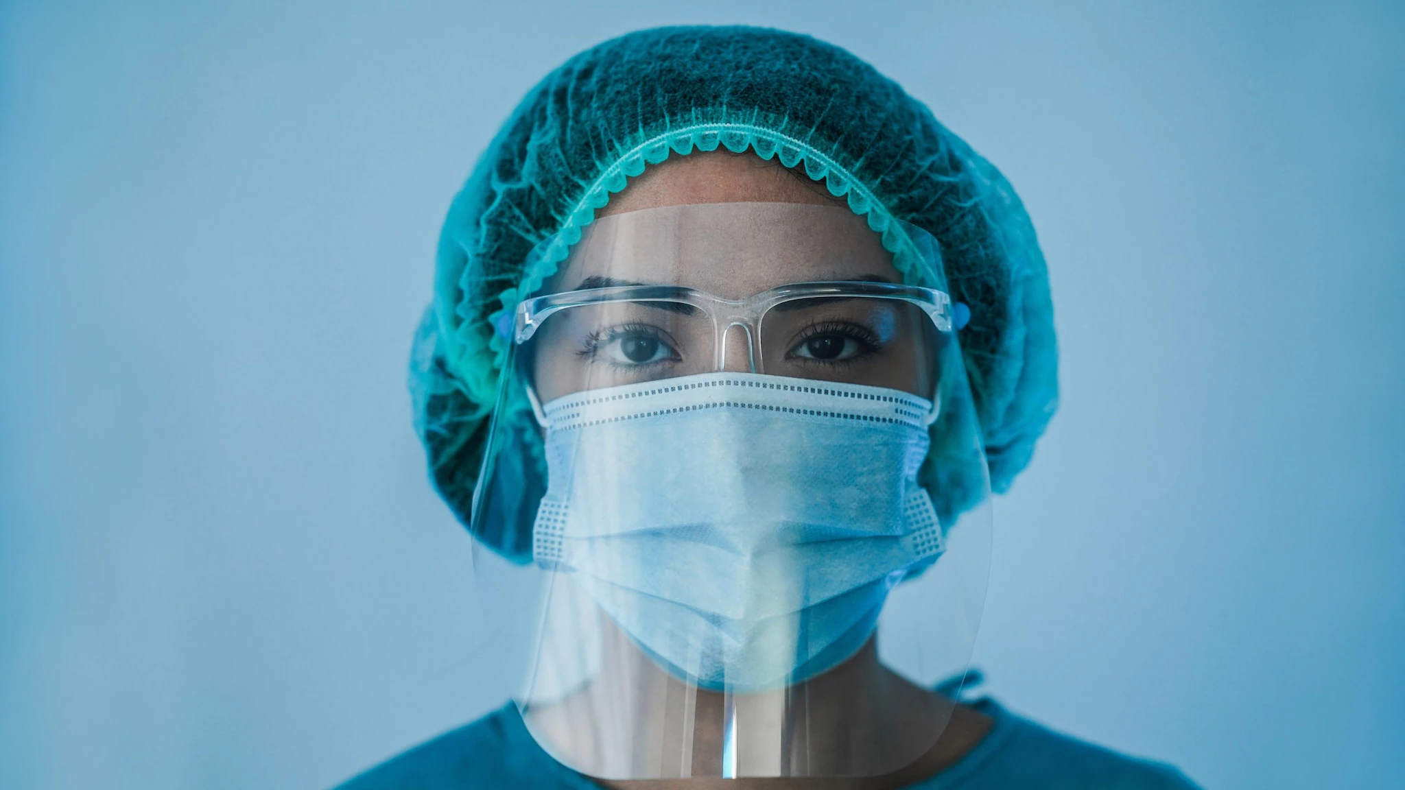 Pandemic thumbnail landing woman wearing hair cover, eye protection, and mask under a face shield