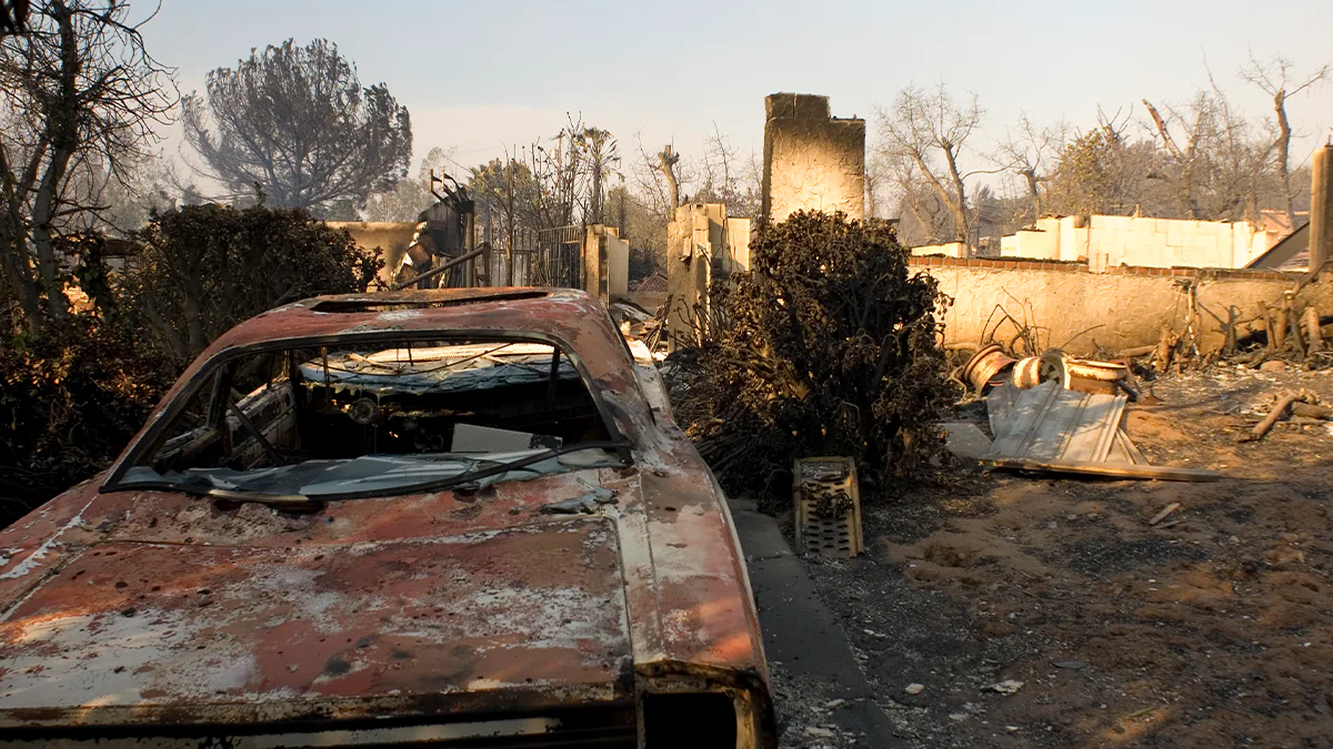 Burned remains of vehicle and house after wildland fire in California. iStock/Getty Images/Plus