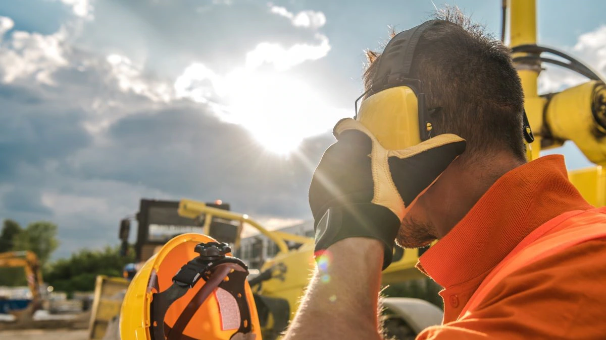 Construction worker with noise-reduction headphones on his head.