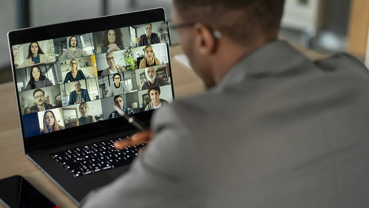 Black man sitting in front of a laptop on a video conference call