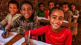 Students in classroom taking notes in notebooks.