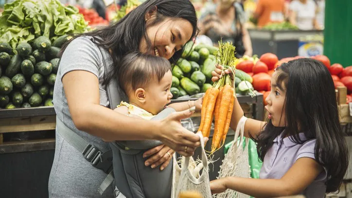 Mother and children in produce section of grocery store