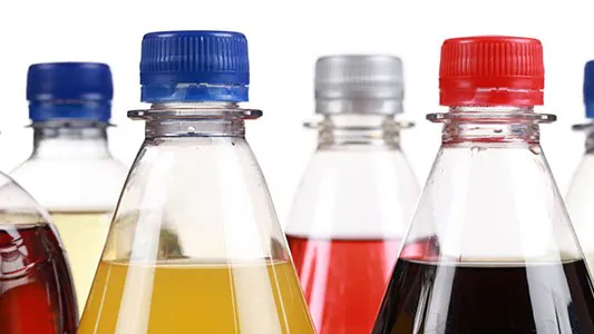 Image of the tops of bottles with sugary drinks.