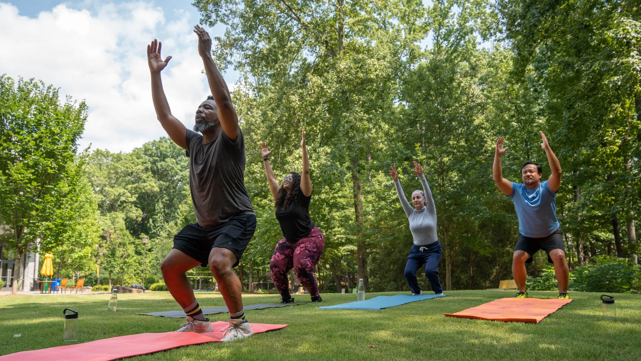 People doing yoga in the park.