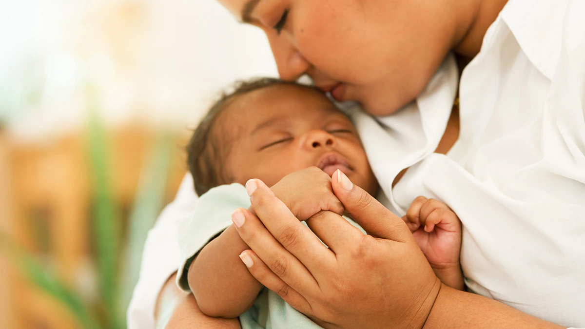 A mother cradles an infant child.