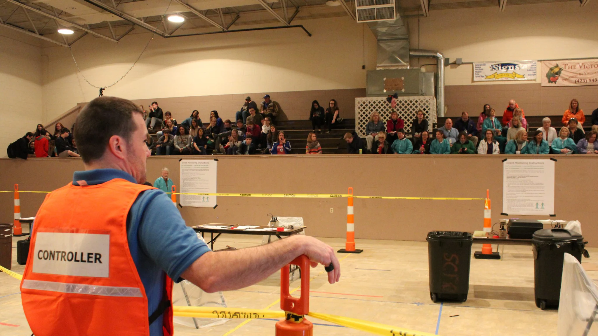 Person with an orange vest on, conducting a training before a CRC exercise.