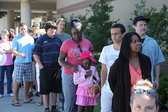 A diverse group of people waiting in line.