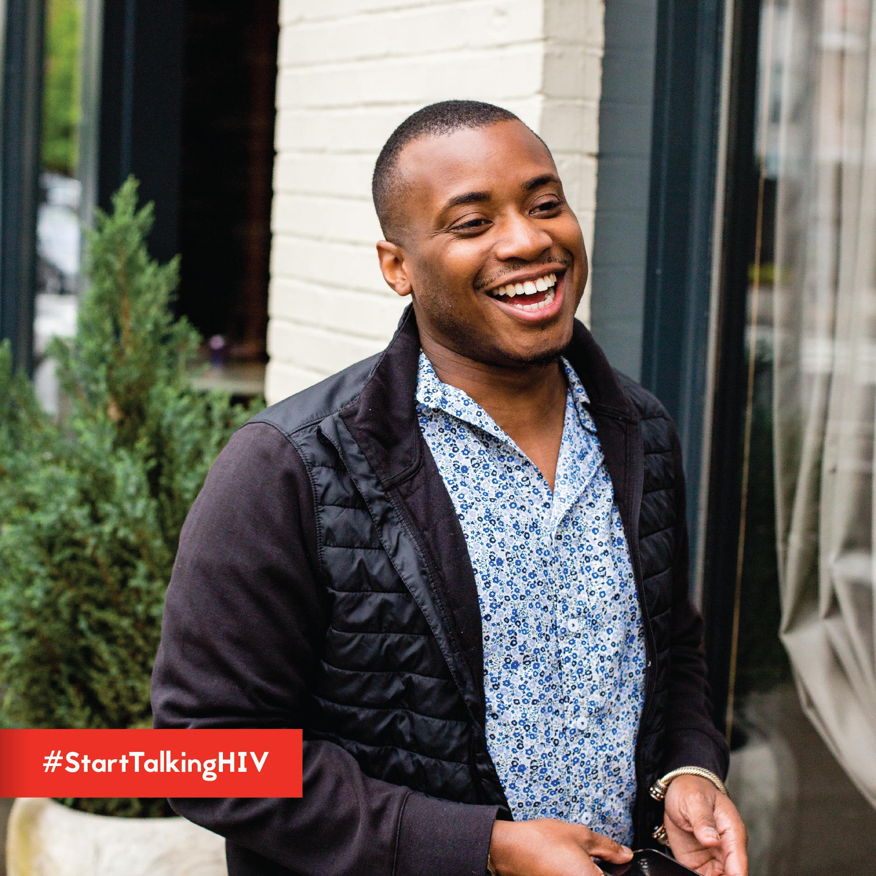 Image displays a man happily smiling while standing outside.