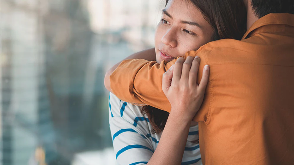 Image of a teen giving her father a hug