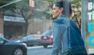 woman sitting looking out into the distance on a city street