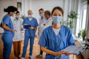 Six healthcare workers together in a room talking.