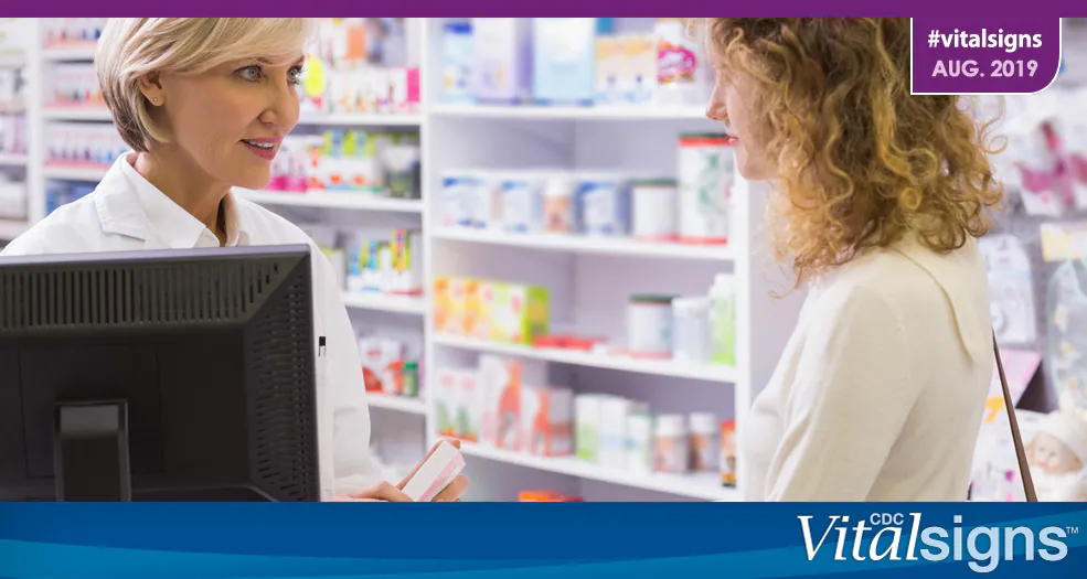 A pharmacist talks with a patient about a prescription.