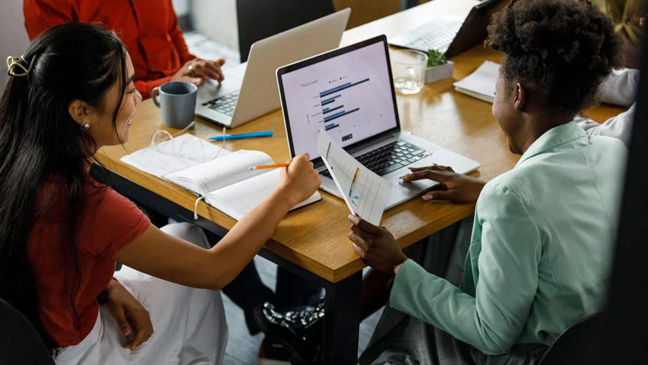 Two students looking at a laptop screen.