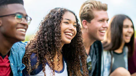 A group of diverse teenagers laughing and smiling.